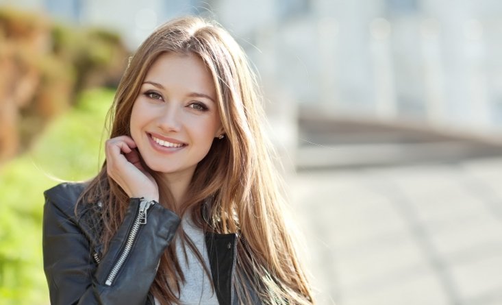 Woman in black leather jacket smiling after cosmetic dentistry in Longmeadow