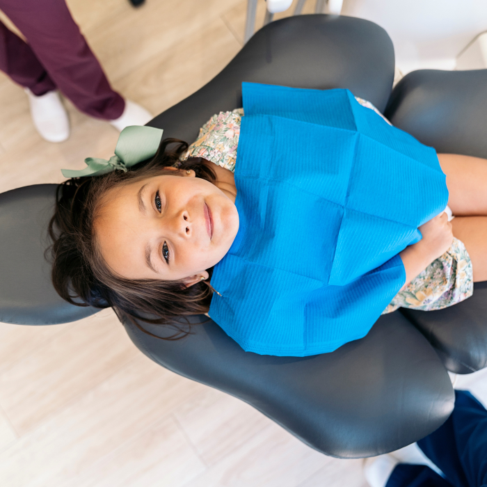 Aerial view of child in dental chair wearing dental bib