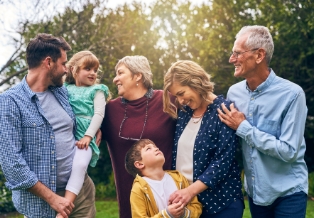 Three generations of a family smiling outdoors