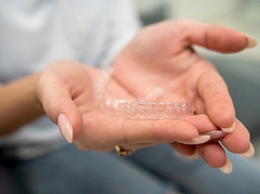Closeup of patient holding clear aligner