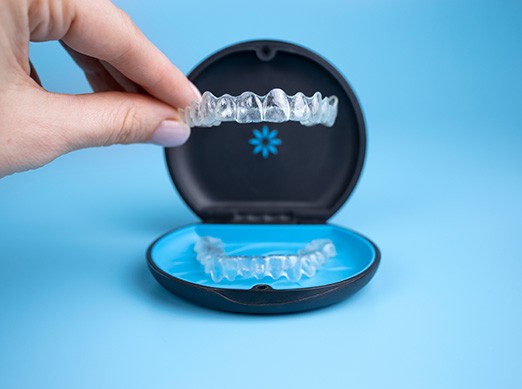 Patient putting clear aligner in case