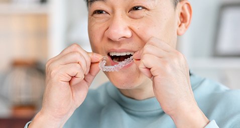 Patient putting on clear aligner