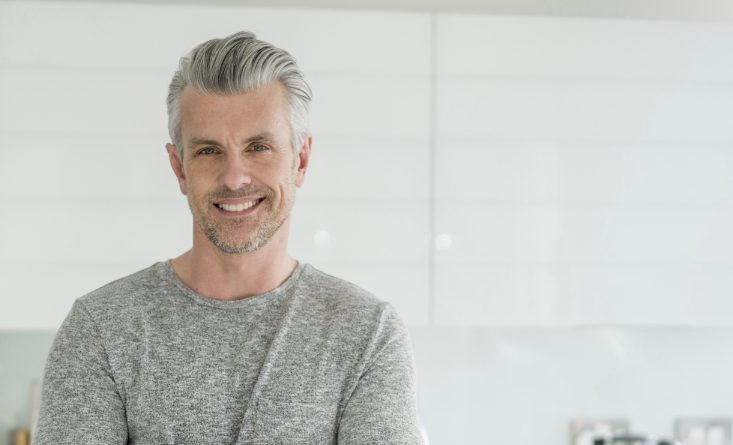 Older man in gray shirt smiling after preventive dentistry in Longmeadow