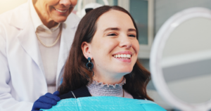 a person smiling into a handheld mirror